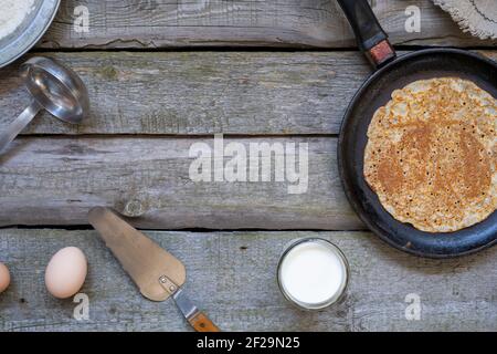 Stack of pancakes on a cast-iron frying pan on a wooden table . Top view. Flat lay Stock Photo