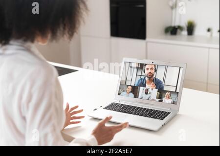 Back view of diverse motivated businesspeople brainstorm engaged in team online webcam meeting briefing. Multiracial colleagues talk speak on video call, involved in web virtual event, presentation Stock Photo