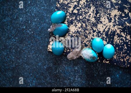 Mystical coloring Easter eggs with twigs on blue background. Background with copy space. Selective focus Stock Photo