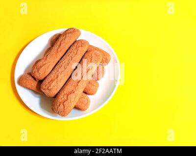 Sweet soft healthy soft spongy sprinkled sugar vanilla cookies (vainillas). Classic Argentine biscuits. Yellow background. High angle shot. Copyspace Stock Photo