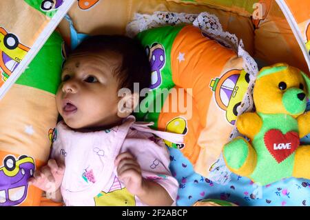 Close up portrait of cute Sweet infant toddler feeling wonder and amazed about surrounding environment. Beautiful Newborn Baby looking something unfam Stock Photo