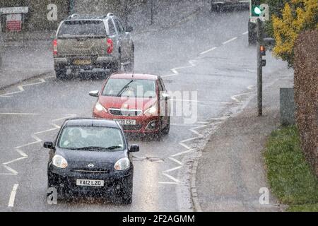 Chippenham, Wiltshire, UK, 11th March, 2021. Car drivers are pictured braving heavy rain in Chippenham as heavy rain showers make their way across Southern England. Credit: Lynchpics/Alamy Live News Stock Photo