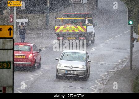 Chippenham, Wiltshire, UK, 11th March, 2021. Car drivers are pictured braving heavy rain in Chippenham as heavy rain showers make their way across Southern England. Credit: Lynchpics/Alamy Live News Stock Photo