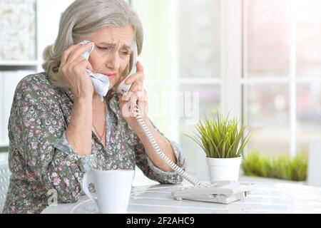 Portrait of ill senior woman calling doctor Stock Photo