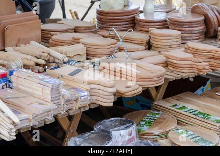 Street counter with wooden products for the kitchen. Cutting boards, rolling pins, graters and other kitchen utensils made of natural wood. Inscriptio Stock Photo