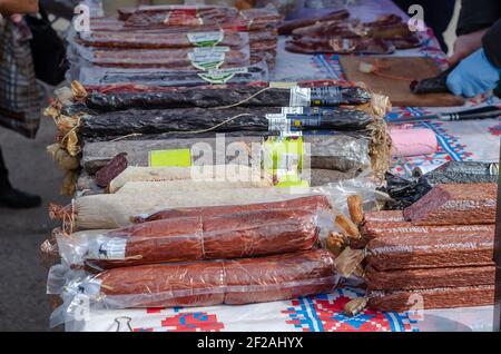 Street counter with smoked and dried sausages. Inscriptions with names in Ukrainian. Nikolaev, Ukraine - March 10, 2021. Stock Photo