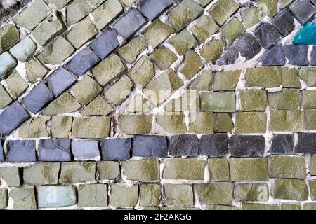 Abstract tile mosaic wall or floor as decorative  background. Soft focus. Close-up. Outdoors. Stock Photo