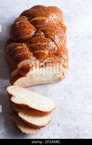 Freshly sliced loaf of challah bread with poppy seeds viewed from above. Stock Photo