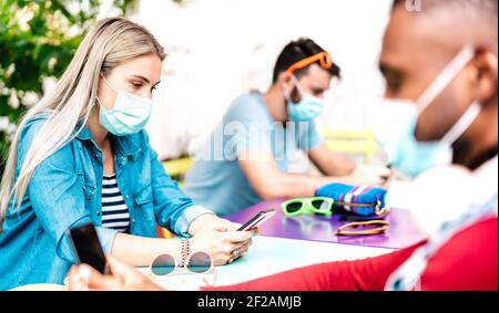 Bored people group using tracking app on mobile smart phones - Milenial friends sharing content online by social media network - New normal technology Stock Photo