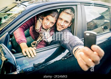 Happy couple at car rent showing electronic key ready for the next road trip - Transportation and vehicle loan concept with satisfied people at rental Stock Photo