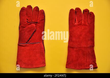 Welder's gloves on a yellow background. Protective accessory for welding. Individual protection means. Stock Photo