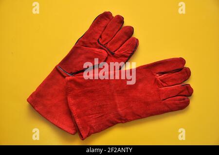 Welder's gloves on a yellow background. Protective accessory for welding. Individual protection means. Stock Photo
