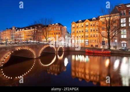 Amsterdam, Netherlands view of the cityscape on the canals at night. Stock Photo
