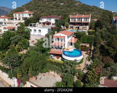 Beautiful summer house villa with three stories and pool under sunny bright blue clear skies surrounded with green natural healty plants. Stock Photo