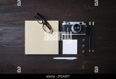 Vintage stationery set and retro photo camera on wood table background. Top view. Flat lay. Stock Photo