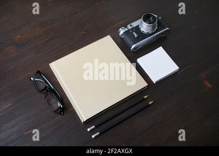 Blank stationery and retro camera on wood table background. Stock Photo