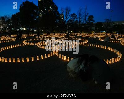 Tokyo, Japan. 11th Mar, 2021. People look at paper lanterns lit for victims of the March 11, 2011 Japan earthquake and tsunami during the 10th anniversary since the disaster. Credit: AFLO/Alamy Live News Stock Photo