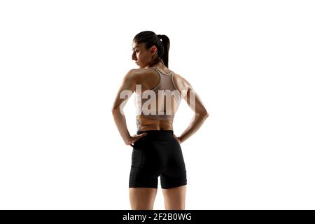 Powerful. Caucasian professional female athlete training isolated on white studio background. Muscular, sportive woman. Concept of action, motion, youth, healthy lifestyle. Copyspace for ad. Stock Photo