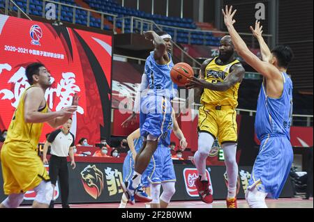 (210311) -- ZHUJI, March 11, 2021 (Xinhua) -- Dominique Jones (2nd R) of Jilin Northeast Tigers passes the ball to teammate Zhong Cheng during the 44th round match between Jilin Northeast Tigers and Beijing Ducks at the 2020-2021 season of the Chinese Basketball Association (CBA) league in Zhuji, east China's Zhejiang Province, March 11, 2021. (Xinhua/Jiang Han) Stock Photo