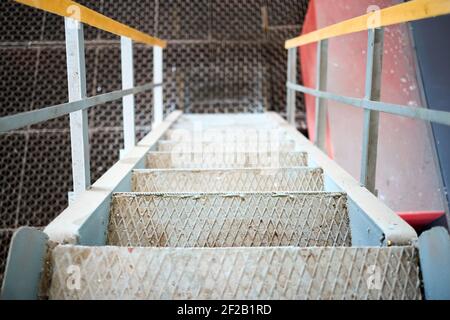 Example of chemical plant steampunk retro style interior part with copyspace. Abstract image of industrial textured rusted stairs going down. Stock Photo