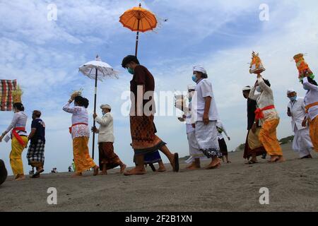 Yogyakarta, Indonesia. 11th Mar, 2021. Javaese Hindu attend a Melasti prayer ceremony amid COVID-19 pandemic, a purification festival held several days before 'Nyepi', the day of silence which marks the Hindu new year this March 14 when devotees are not allowed to travel, work, at the Parangkusumo beach in Yogyakarta, Indonesia on March 11 2021. (Photo by Devi Rahman/INA Photo Agency/Sipa USA) Credit: Sipa USA/Alamy Live News Stock Photo