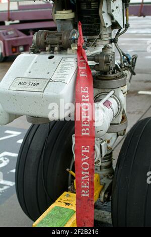 Safety warning sign on the nose landing gear of an Uzbekistan Airways Boeing 757 passenger plane in the apron area at Birmingham Airport, England. Stock Photo