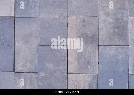 Old street tiles in grey texture, background close-up