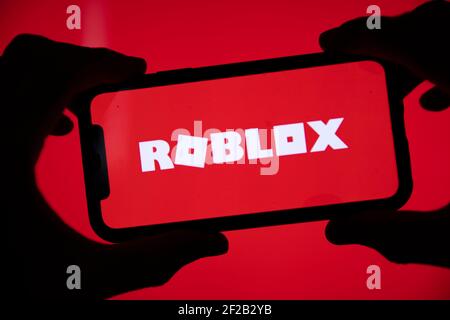 LONDON, UK - March 2021: Person holding a smartphone with Roblox game logo Stock Photo