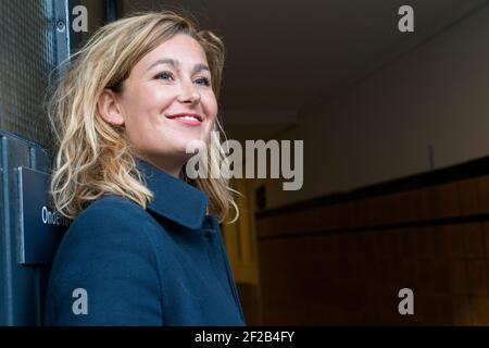 Amsterdam, Netherlands. Young adult causasian female standing at a building's door, to recieve and welcome guests and visitors. Stock Photo