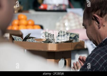 Member of the public prays before altar of Japanese Yen notes in the Hiwatari Matsuri - Fire Walking Festival, Mount Takao, Hachioji, Japan Stock Photo