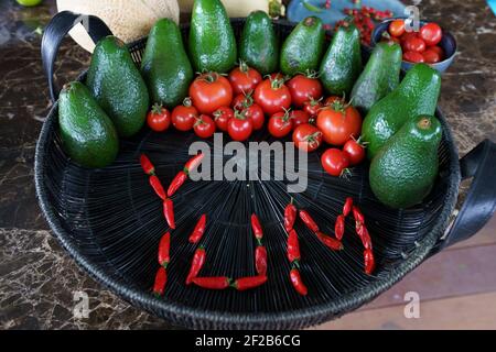 Avocados and tomatoes arranged in a still life display with the word ...