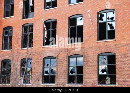Rows of broken windows in a brick wall, in an old, abandoned building Stock Photo