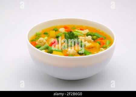 Mixed veg curry or kurma  tasty indian dish made of different vegetables like cauliflower, carrot, potato, green peas and garnished with onion pieces Stock Photo