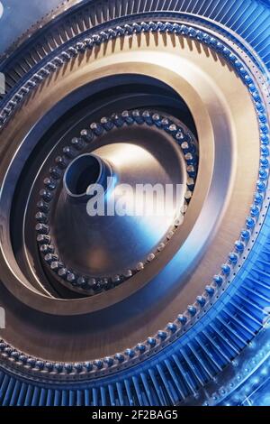 The rotor disk with the blades of a turbojet gas turbine engine with a blue glow. Elements, parts and mechanisms of turbines. Energy and mechanical en Stock Photo