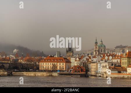 Postcard view of Lesser Town in mist from Charles Bridge,Czech republic.Famous tourist destination.Prague panorama.Foggy morning in city.Amazing