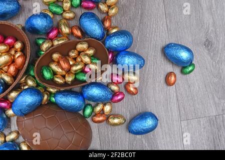 Pile or group of multi colored and different sizes of colourful foil wrapped chocolate easter eggs in pink, blue, gold and green. Stock Photo