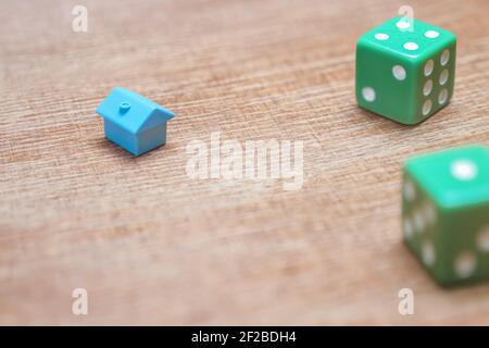 Property risks and chances concept. Miniature house and dice on wood background mortgage loans real estate taxes and debts. Symbol house investment Stock Photo