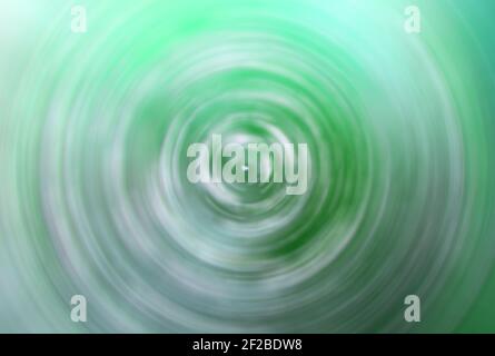 Green concentric colorful circles, abstract blurred vortex, swirl. Stock Photo