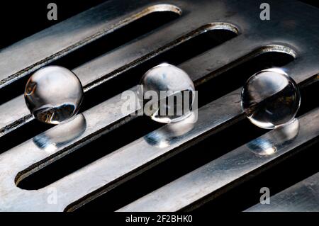 Three crystal balls in different rails on inox steel metal support in black background Stock Photo