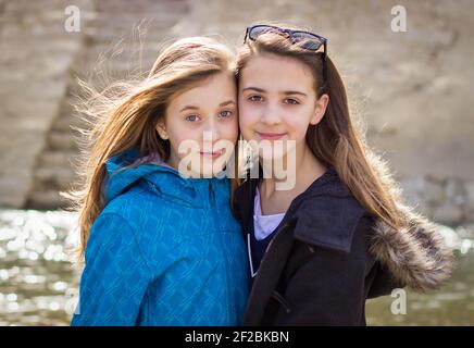 Two teen girls outdoors being affectionate with each other. Stock Photo