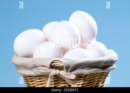 Chicken Eggs in a straw Basket, A lot of White Fresh Raw eggs in a container, Natural Eko Product, Easter preparing Copyspace Stock Photo