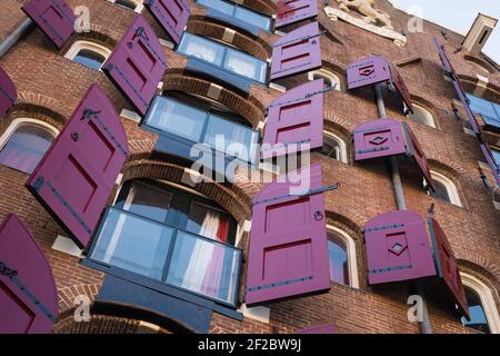 Red shutters on the Deen Dragt building on Singel, Amsterdam, Netherlands. Stock Photo