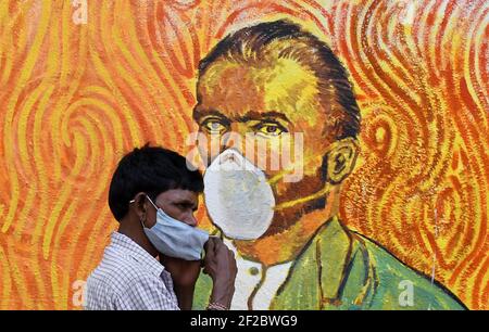 Mumbai, Maharashtra, India. 11th Mar, 2021. A man wearing a face mask walks past a graffiti of Vincent Van Gogh in Mumbai.Despite the spike in coronavirus cases in Maharashtra state, people do not adhere to the guidelines given by the government to follow social distance, wear mask and use sanitizer. Credit: Ashish Vaishnav/SOPA Images/ZUMA Wire/Alamy Live News Stock Photo