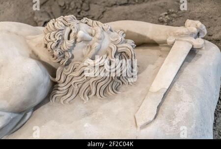 Dead warrior - Small Pergamene Votive Offering. Roman marble statue, copy of original greek statue in MANN (Museo archeologico Nazionale di Napoli) Stock Photo