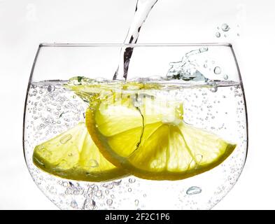 Carbonated drink and two slices of lemon in gin glass Stock Photo