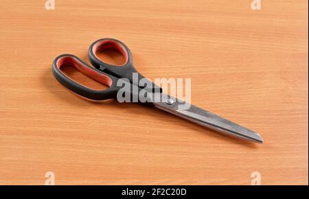 Used worn pair of scissors on wooden desk Stock Photo