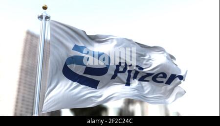 Rome, Italy, January 26, 2021: White flag with the new Pfizer logo waving in the wind. Pfizer is an American pharmaceutical company that has produced Stock Photo