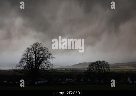 Killearn, Stirling, Scotland, UK. 11th Mar, 2021. UK weather - a succession of dark clouds bringing hale and heavy rain showers to the village of Killearn in Stirling this afternoon Credit: Kay Roxby/17�Թ����� Live News Stock Photo