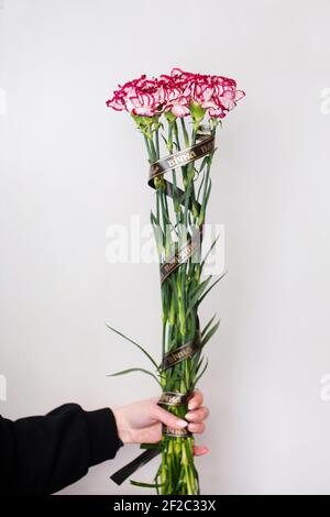 Woman holding a funeral bouquet of carnations Stock Photo