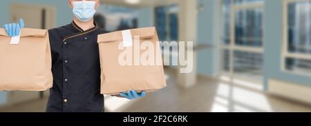 Delivery man holding cardboard packages in medical rubber gloves and mask. copy space. Fast and free Delivery. Online shopping and Express delivery Stock Photo